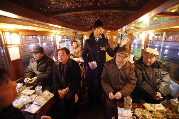 Citizens sit in a sightseeing boat and cruise on the moat in Jinan, capital of east China's Shandong Province, Dec. 29, 2010. 