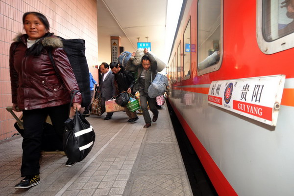 A migrant worker walks past a train at Hangzhou railway station, Zhejiang Province on Dec 30, 2010. 