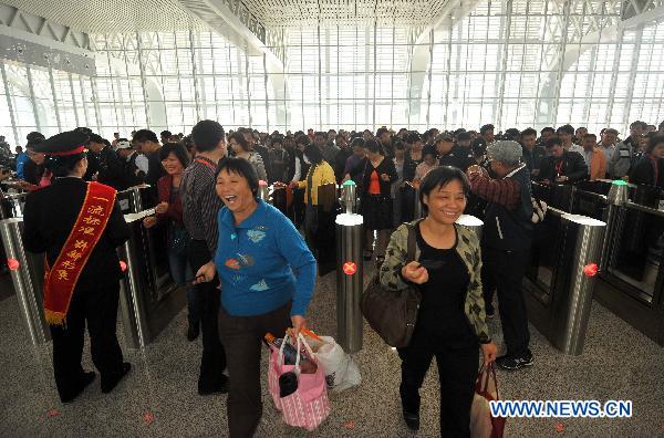 Passengers check in to board on the train traveling from Hainan's capital Haikou to the famous tourist destination Sanya in Haikou, south China's Hainan Province, Dec. 30, 2010. 