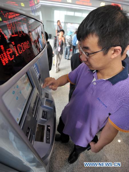 A man buys ticket for the train traveling from Hainan's capital Haikou to the famous tourist destination Sanya in Haikou, south China's Hainan Province, Dec. 30, 2010.