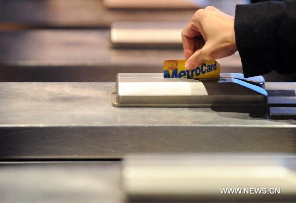 A passenger uses a Metro card to get into a subway station in New York, the United States, Dec. 30, 2010. 