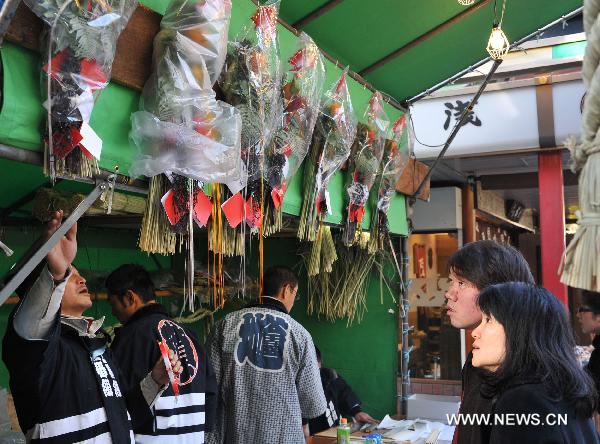 Locals select traditional New Year decorations during the New Year holiday at a shop in Tokyo, capital of Japan, on Dec. 29, 2010. 