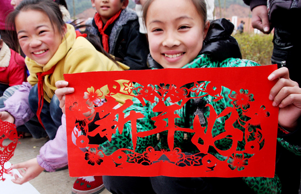 Students show their paper-cutting works during a traditional Chinese paper cutting activity for the upcoming new year in Dexing, Jiangxi Province, Dec. 30, 2010. Paper-cutting works are usually used to decorate doors and windows.