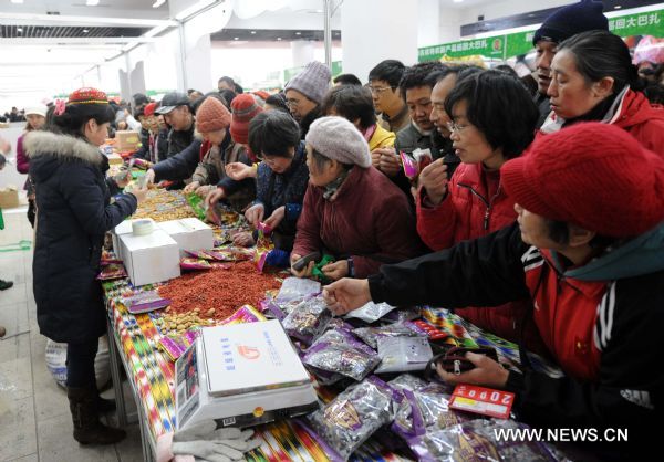 Consumers buy dried fruits produced in northwest China's Xinjiang Uygur Autonomous Region, at a bazar in Nanjing, capital of east China's Jiangsu Province, Jan. 2, 2011. 