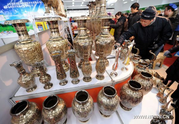 Consumers select craftworks produced in northwest China's Xinjiang Uygur Autonomous Region, at a bazar in Nanjing, capital of east China's Jiangsu Province, Jan. 2, 2011. 