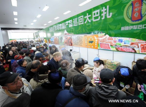 Consumers buy foods produced in northwest China's Xinjiang Uygur Autonomous Region, at a bazar in Nanjing, capital of east China's Jiangsu Province, Jan. 2, 2011. 