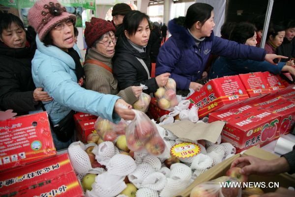 Consumers buy apples produced in northwest China's Xinjiang Uygur Autonomous Region, at a bazar in Nanjing, capital of east China's Jiangsu Province, Jan. 2, 2011. 