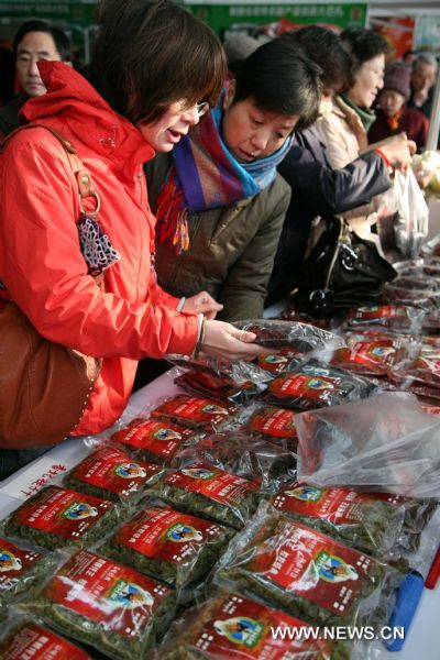 Consumers buy dried fruits produced in northwest China's Xinjiang Uygur Autonomous Region, at a bazar in Nanjing, capital of east China's Jiangsu Province, Jan. 2, 2011. 