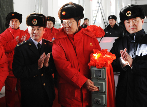 Yao Wei (C), general manager of the Pipeline Branch of Petro China Co Ltd (PBPC), pushes a button to make the pipeline begin operating at a plant in Mohe County, northeast China's Heilongjiang Province, Jan 1, 2011.