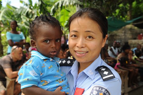 Tianjin police officer Liu Jinjin holds a Haitian baby during her peacekeeping mission in Haiti. 
