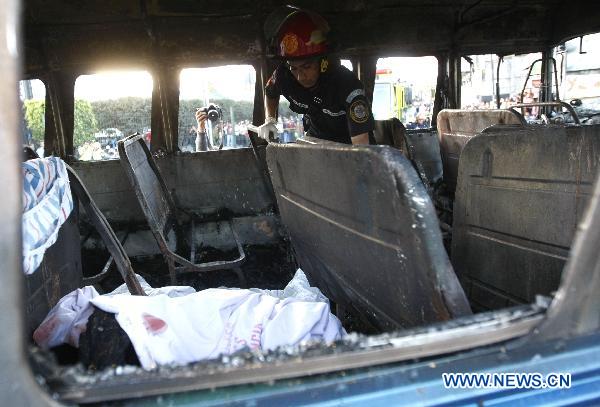 A firefighter works inside the remains of a charred bus in Guatemala City, capital of Guatemala, on Jan. 3, 2011.