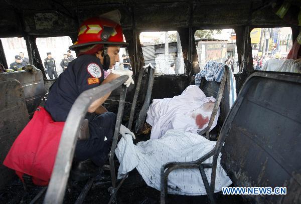 A firefighter inspects the inside of a charred bus in Guatemala City, Guatemala's capital, on Jan. 3, 2011. 