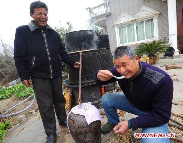 Villager Fei Zhiliang (R) makes homemade liquor for Spring festival feasts in Changxing of east China's Zhejiang Province, Jan. 5, 2011. 
