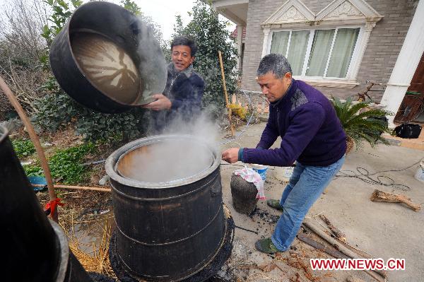Villager Fei Zhiliang (R) makes homemade liquor for Spring festival feasts in Changxing of east China's Zhejiang Province, Jan. 5, 2011.