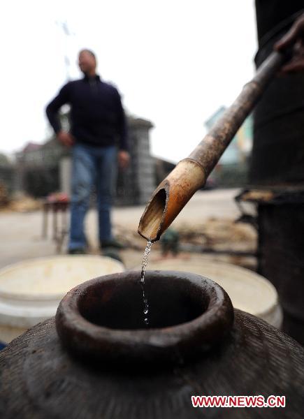 Liquor made in a farmhouse flows to a jar as villagers prepare for the upcoming Spring Festival feasts in Changxing of east China's Zhejiang Province, Jan. 5, 2011.