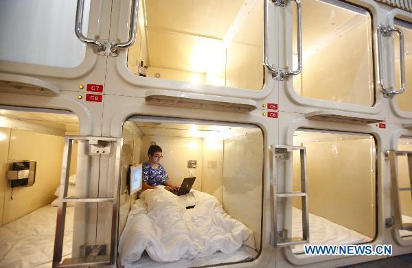 A staff member tries the bed at a 'capsule inn' in Shanghai, east China, Jan. 6, 2010.