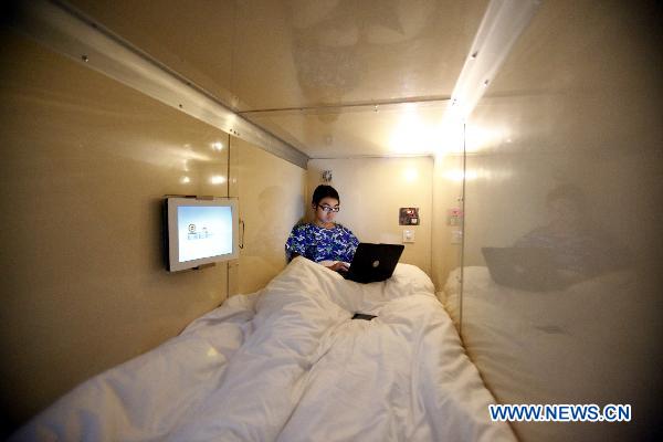 A staff member tries the bed at a 'capsule inn' in Shanghai, east China, Jan. 6, 2010. 