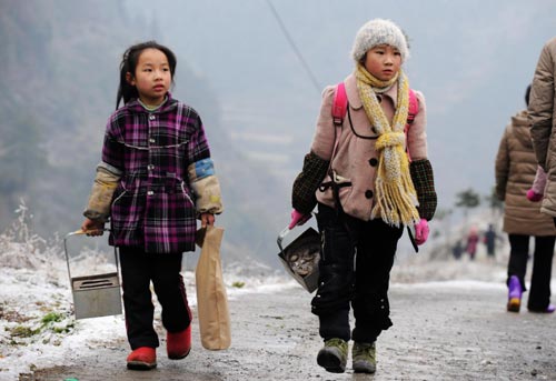 Holding makeshift hand-stoves, students walk to school on an iced mountain road in Xinhuang Dong Autonomous County in western-most Hunan Province, Jan 6, 2011.