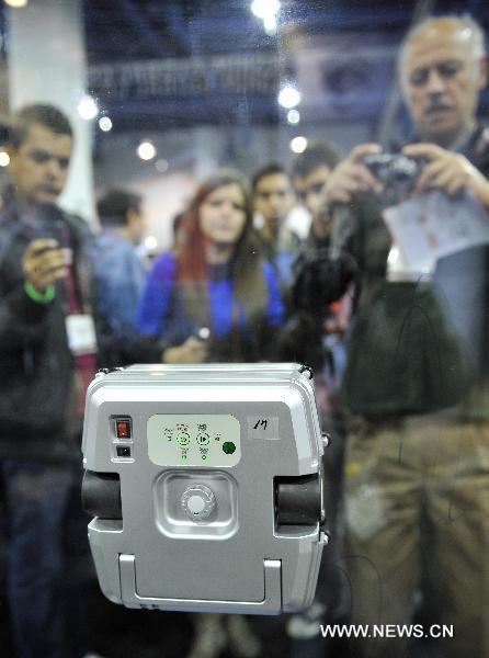 People watch the window cleaning robot Windoro during the 2011 International Consumer Electronics Show in Las Vegas, the United States, Jan. 8, 2011. 