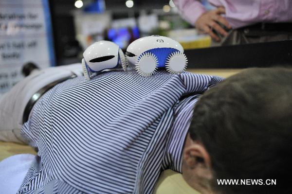 People try out the Massage from Robot Whee Me during the 2011 International Consumer Electronics Show in Las Vegas, the United States, Jan. 8, 2011. 