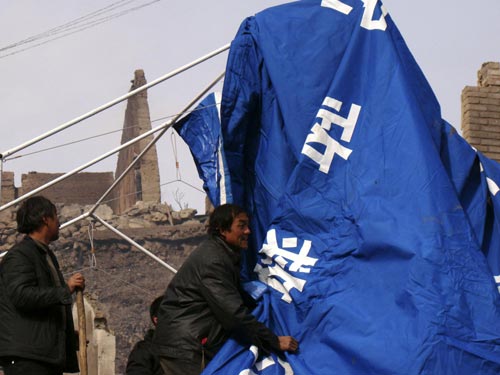 People left homeless by a blaze put up tents in Qawa Village, Zhouqu County in northwest China's Gansu Province, Jan 9, 2011.