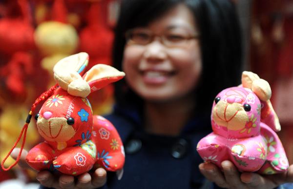 A citizen shows two rabbit toys at a store in Nanchang, capital of central China's Jiangxi Province, Jan. 9, 2011. 