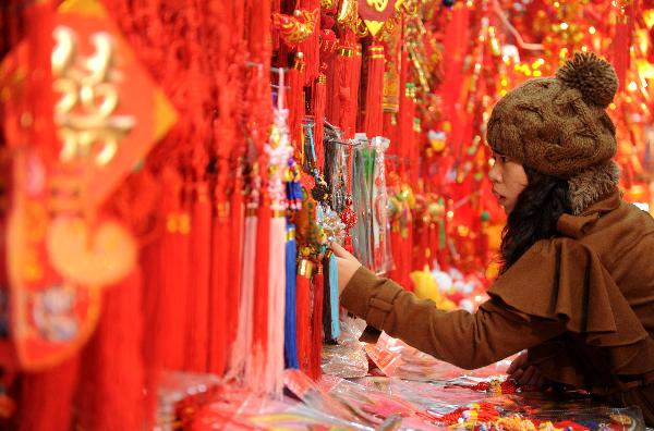 A citizen chooses decorations for the upcoming Spring Festival at a store in Nanchang, capital of central China's Jiangxi Province, Jan. 9, 2011.