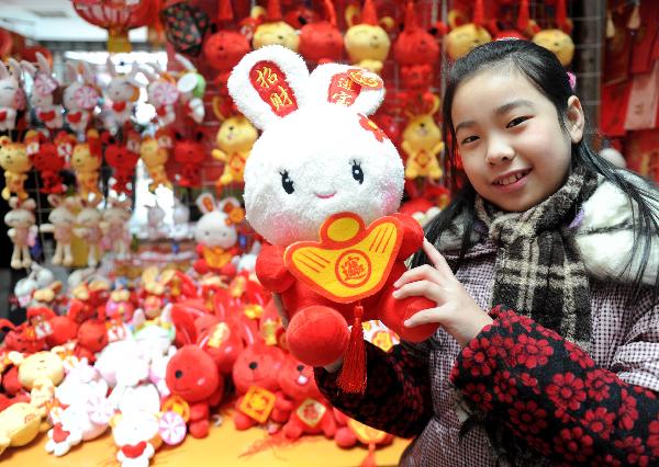Ding Wenjie shows her toy at a store in Nanchang, capital of central China's Jiangxi Province, Jan. 9, 2011. 