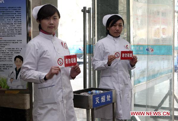 Two nurses hold warning signs that read 'Smoking is strictly prohibited' in Chinese in a hospital in Xiangyang City, central China's Hubei Province, Jan. 8, 2011. 