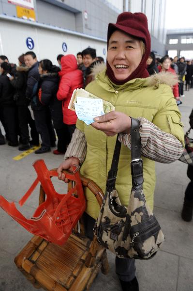 A migrate worker named Yuan Fenghua shows her train tickets at Ningbo International Convention and Exhibition Center in Ningbo City, east China&apos;s Zhejiang Province on Jan. 9, 2011. 