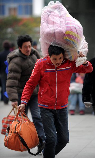 A luggage-carring passenger rushes for his train at Nanchang Railway Station in Nanchang, capital of east China&apos;s Jiangxi Province, Jan. 9, 2011.