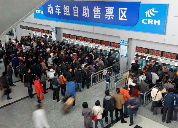 Passengers queue up to buy train tickets from ticket machines in Fuzhou Railway Station in Fuzhou, southeast China&apos;s Fujian Province, Jan. 9, 2011. 