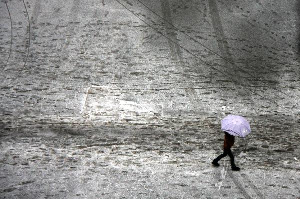 A man walks on a road coated by ice and snow in Guiyang City, capital of southwest China's Guizhou Province on Jan. 10, 2011. 