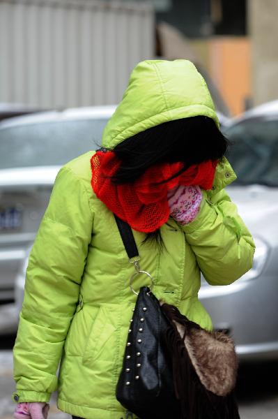 A woman uses her scarf to prevent her face from cold in Guiyang City, capital of southwest China's Guizhou Province on Jan. 10, 2011. 