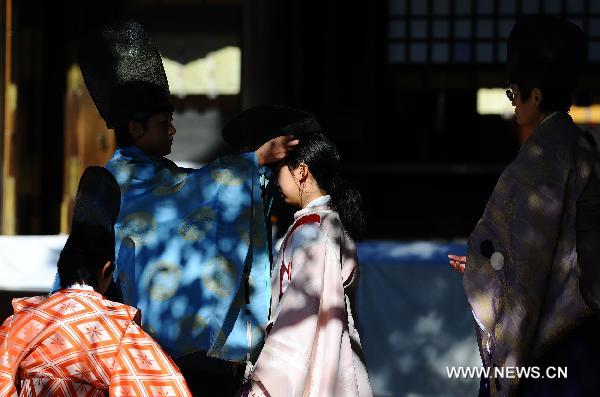 A youth receives a hat during the 'Genpuku' ceremony held in Meiji Shrine in Tokyo, capital of Japan, on Jan. 10, 2010, the Coming of Age Day.