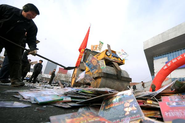 A bulldozer destroys pirated audio-visual products during a campaign against production and trade of pirated publications in Taiyuan, capital of north China's Shanxi Province, Jan. 10, 2010. 
