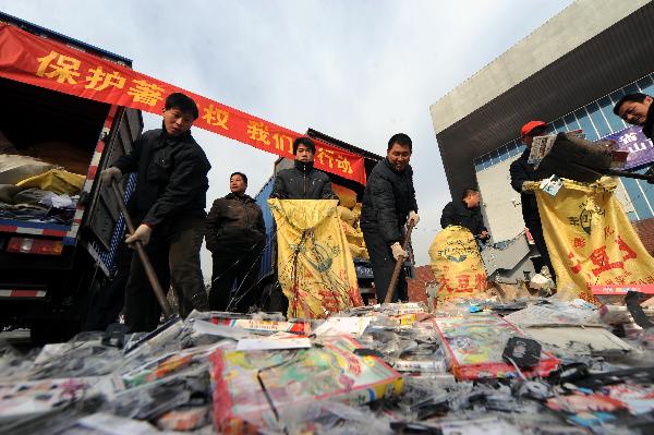 Workers clean pirated audio-visual products just destroyed during a campaign against production and trade of pirated publications in Taiyuan, capital of north China's Shanxi Province, Jan. 10, 2010. 