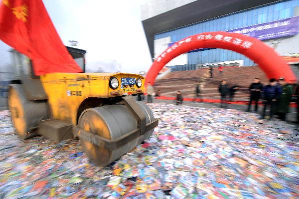 A bulldozer destroys pirated audio-visual products during a campaign against production and trade of pirated publications in Taiyuan, capital of north China's Shanxi Province, Jan. 10, 2010. 