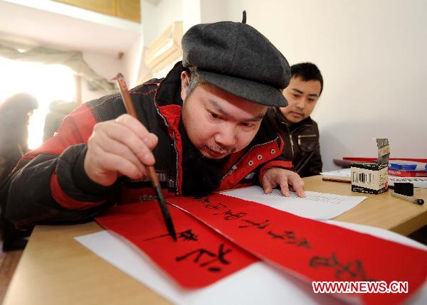 A handicapped resident writes Spring Festival couplets during his calligraphy lesson in Hangzhou, capital of east China's Zhejiang Province, Jan. 10, 2010. 