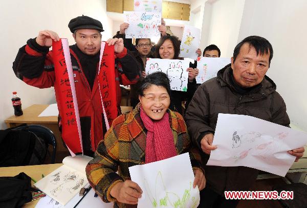 Handicapped residents show their pictures and couplets after lessons in Hangzhou, capital of east China's Zhejiang Province, Jan. 10, 2010. 