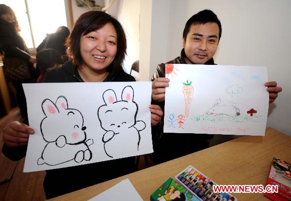 Handicapped residents show their pictures during a painting lesson in Hangzhou, capital of east China's Zhejiang Province, Jan. 10, 2010. Painting and calligraphy lessons were held for handicapped residents prior to the Spring Festival in the community of Xixi in Hangzhou. 