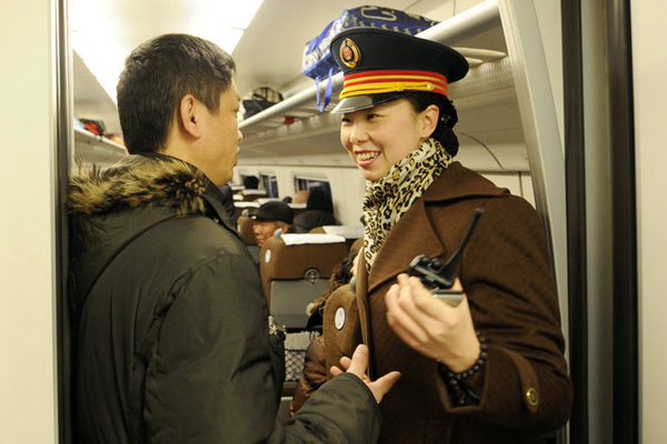 A passenger asks a stewardess for help on the first train to travel on the new high-speed rail link between Jilin and Changchun, Jan.11, 2011. 
