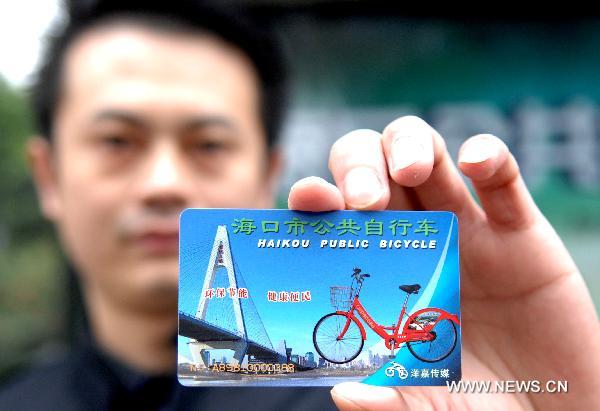 A staff presents a public bicycle card in Haikou, capital of south China's Hainan Province, Jan. 11, 2011. 