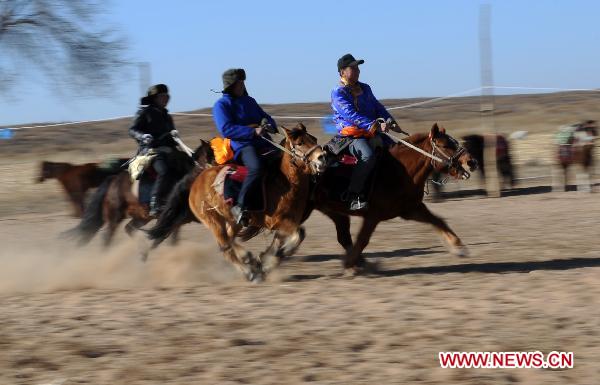 People take part in a horse racing competition in Etogqian Qi, north China's Inner Mongolian Autonomous Region, Jan. 12, 2011.