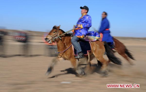 People take part in a horse racing competition in Etogqian Qi, north China's Inner Mongolian Autonomous Region, Jan. 12, 2011.