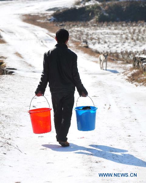 A villager goes outdoors to wash clothes in Ziyuan County, south China's Guangxi Province, Jan. 12, 2011. 