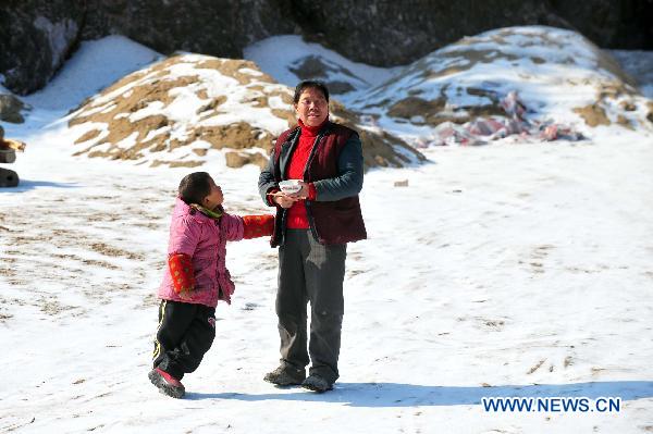 Villagers go outdoors to enjoy the sun in Ziyuan County, south China's Guangxi Province, Jan. 12, 2011. 