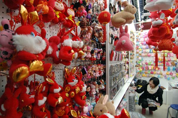 Photo taken on Jan. 1, 2011 shows a shop owner organizing items in Yiwu, eastern China's Zhejiang Province.