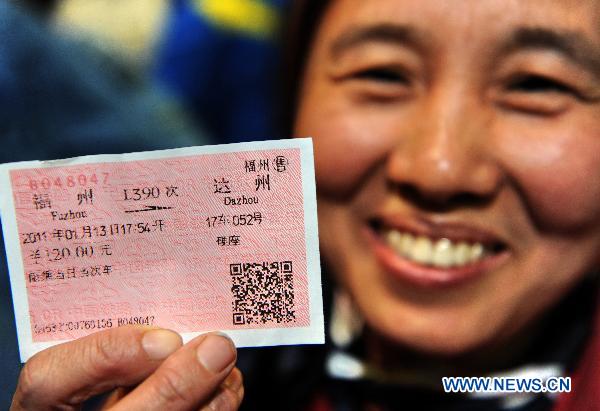Migrant worker Li Jing from southwest China&apos;s Sichuan Province shows her railway ticket in Fuzhou Railway Station in Fuzhou, southeast China&apos;s Fujian Province, Jan. 13, 2011. A total of 1,936 migrant workers began their journey home on Temporary Train L390, the first special train for migrant workers in Fuzhou Railway Station during the Spring Festival travel of 2011. [Xinhua]