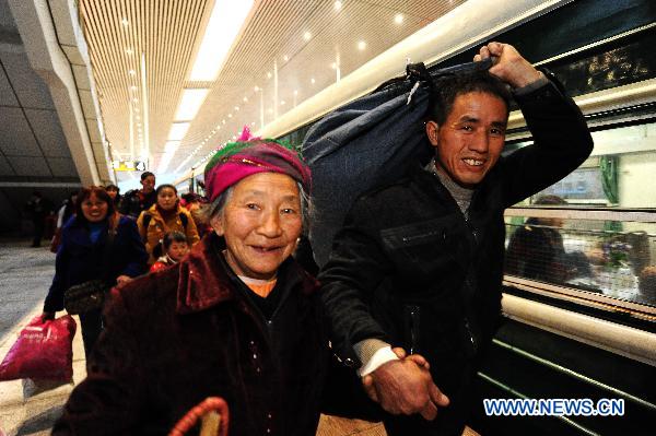 Migrant workers are seen boarding in Fuzhou Railway Station in Fuzhou, southeast China&apos;s Fujian Province, Jan. 13, 2011. A total of 1,936 migrant workers began their journey home on Temporary Train L390, the first special train for migrant workers in Fuzhou Railway Station during the Spring Festival travel of 2011. [Xinhua] 